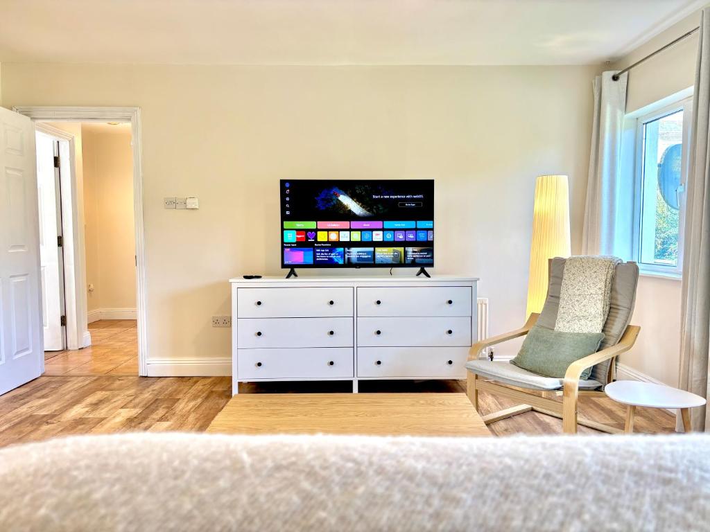 a bedroom with a television on a dresser with a chair at Bay Breeze Hideaway in Cobh