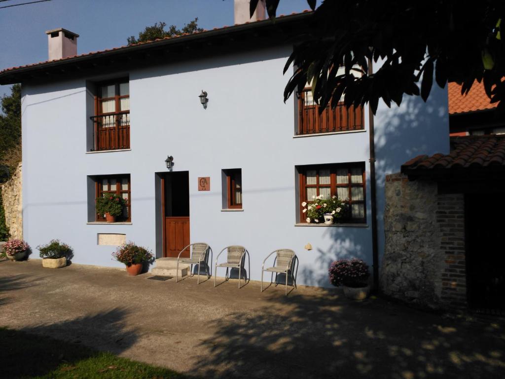 una casa blanca con sillas delante en Casa Rural Casa Azul, en Villahormes