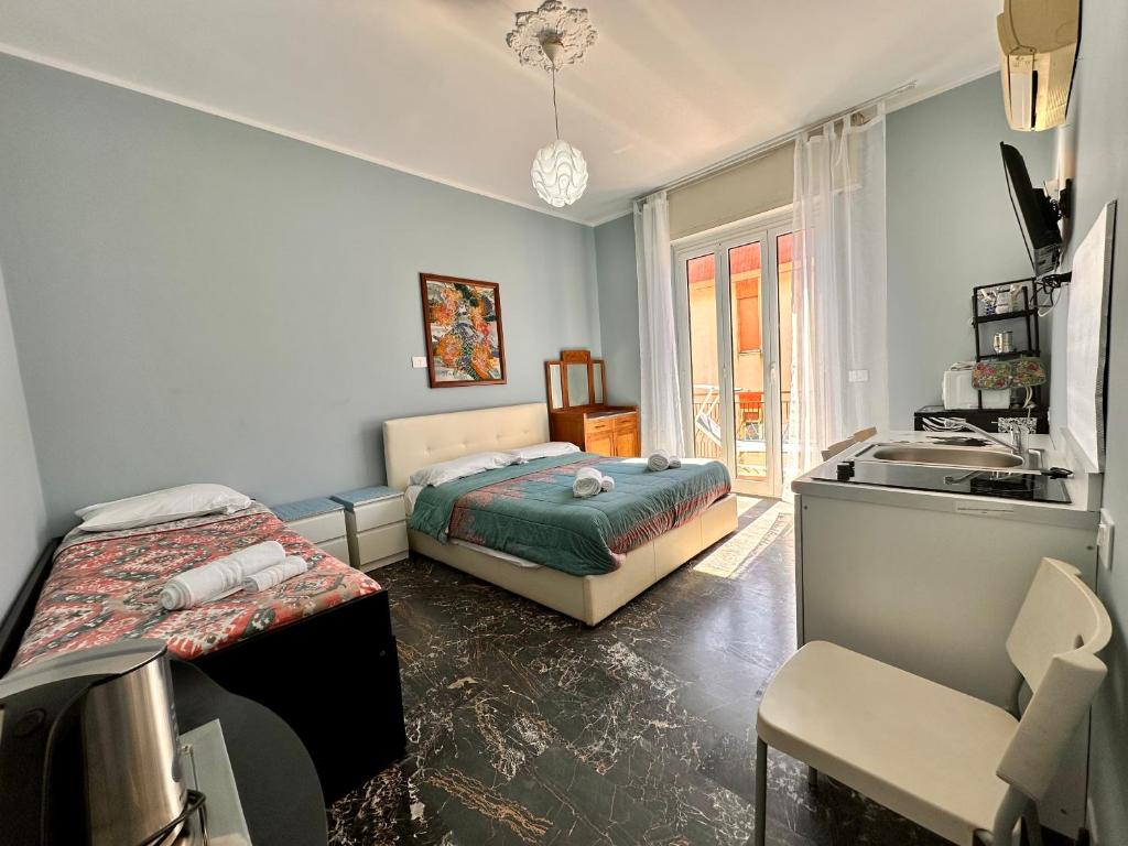 a room with two beds and a sink in it at La Fenice - Studio Flat in Finale Ligure