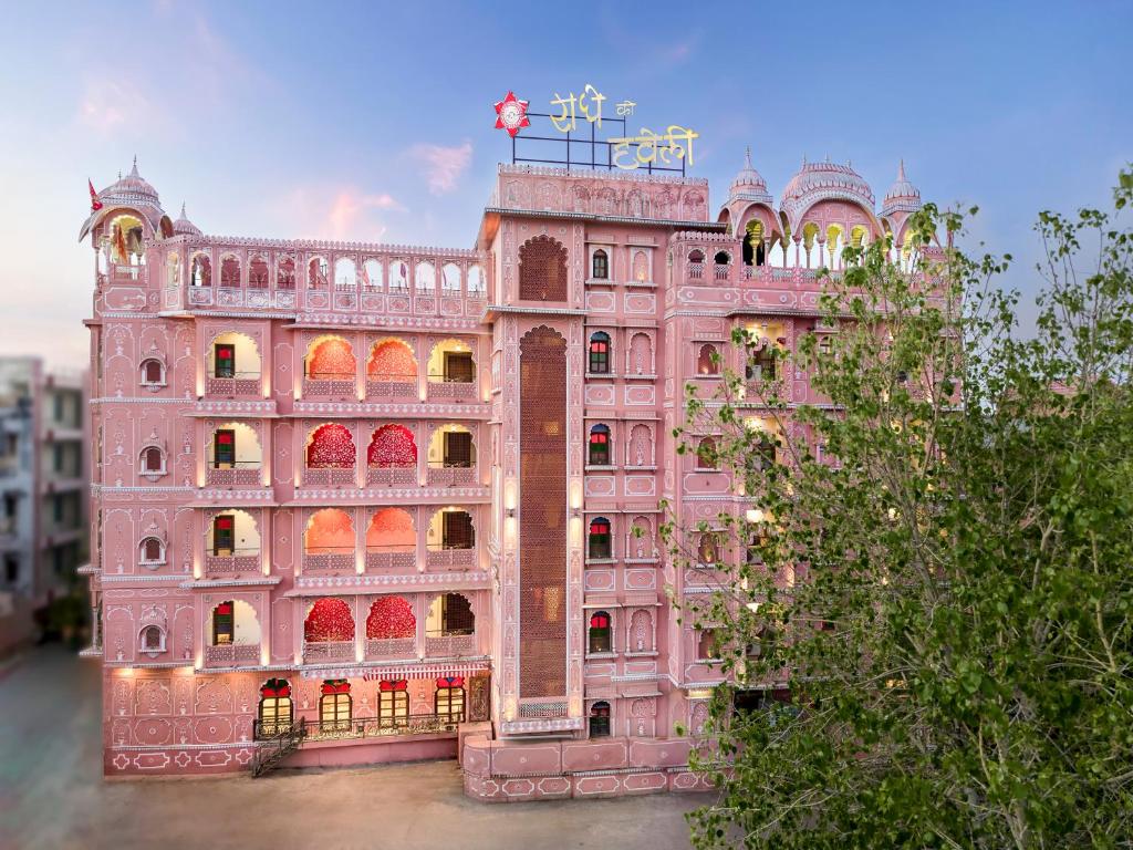 a pink building with a flag on top of it at Radhey Ki Haveli in Khātu