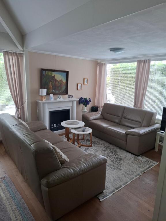 a living room with a couch and a fireplace at Kustverhuur, Park Schoneveld Duinroos 131 in Breskens