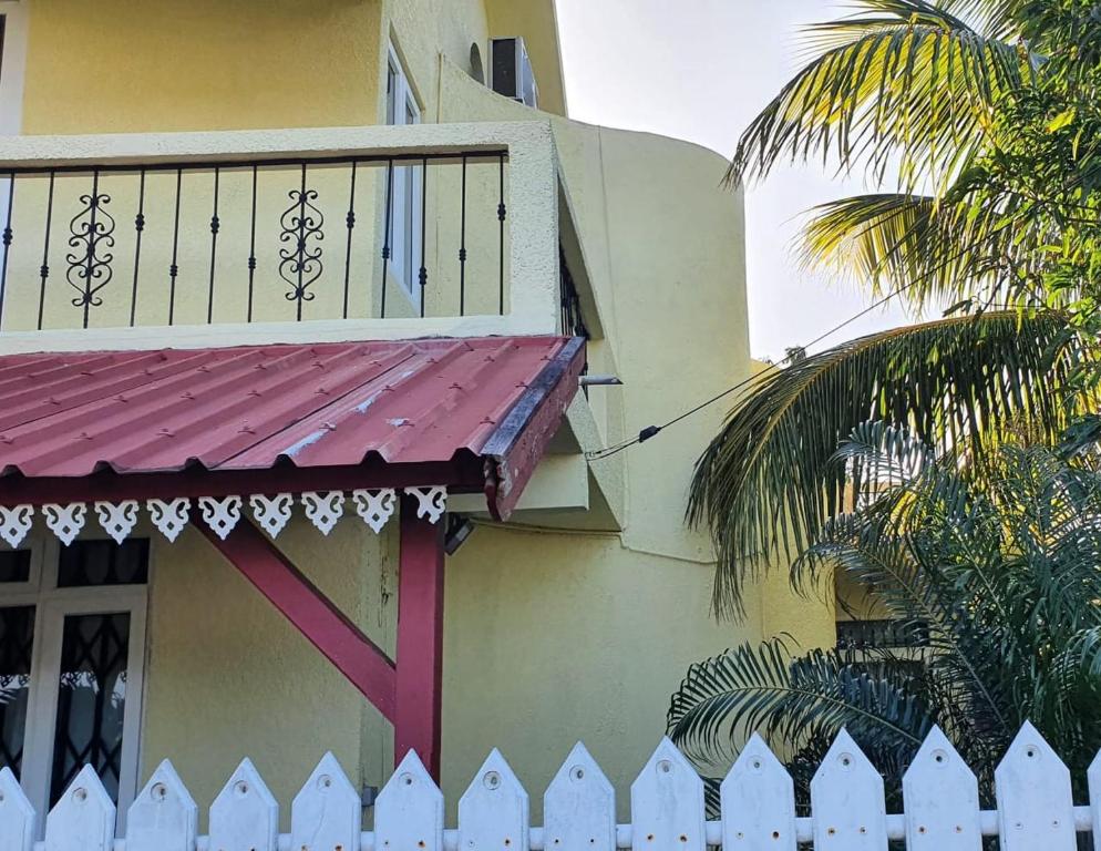 a white fence next to a building with a balcony at The nest in Goodlands