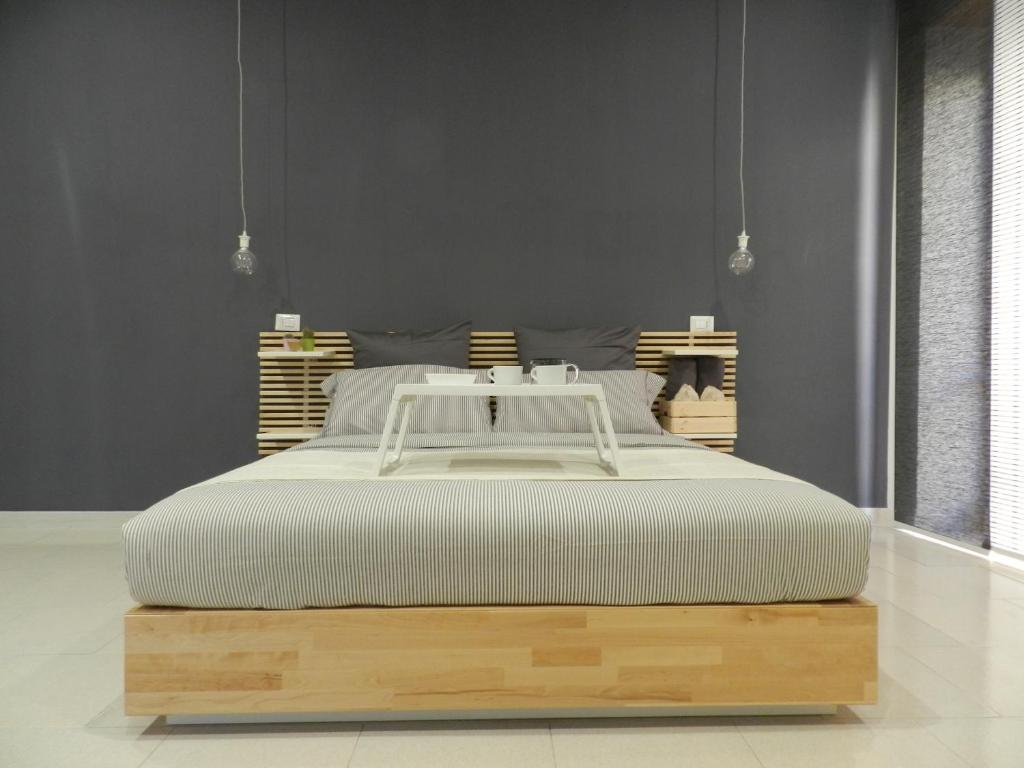 ナポリにあるMola Roomsの白いベッド1台、木製のプラットフォームが備わるベッドルーム1室が備わります。