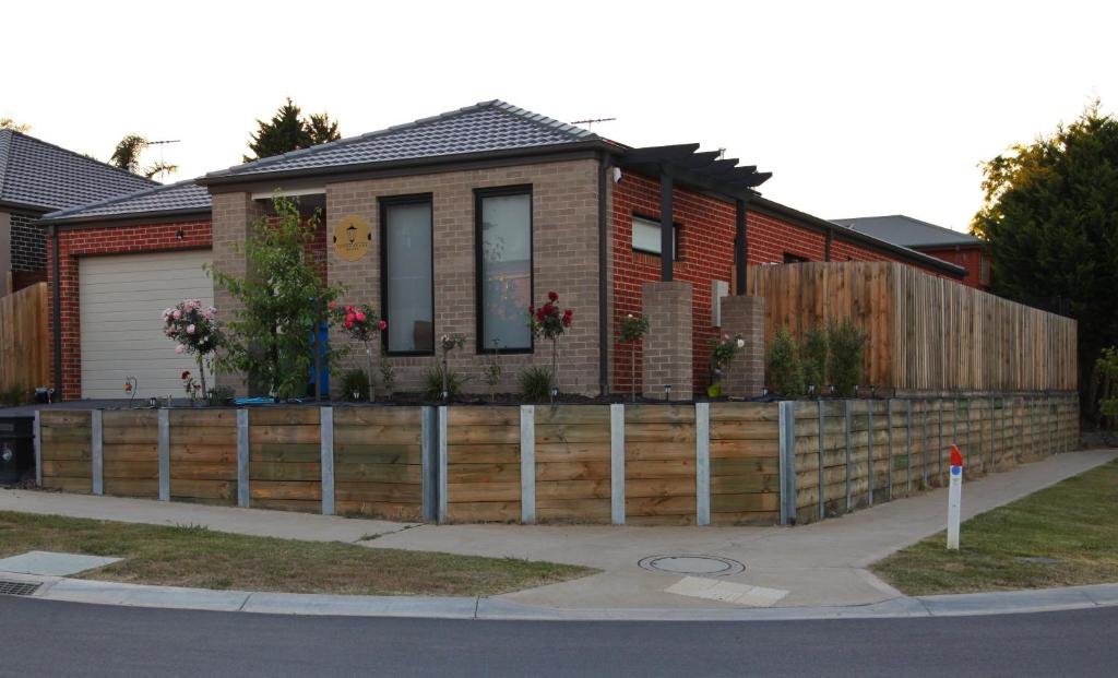 uma casa com uma cerca de madeira em frente em London Park Resort em Narre Warren