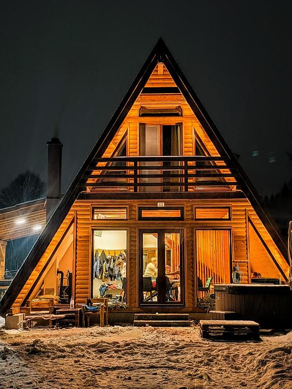a large wooden house with large windows at night at Lunor House in Izvoare