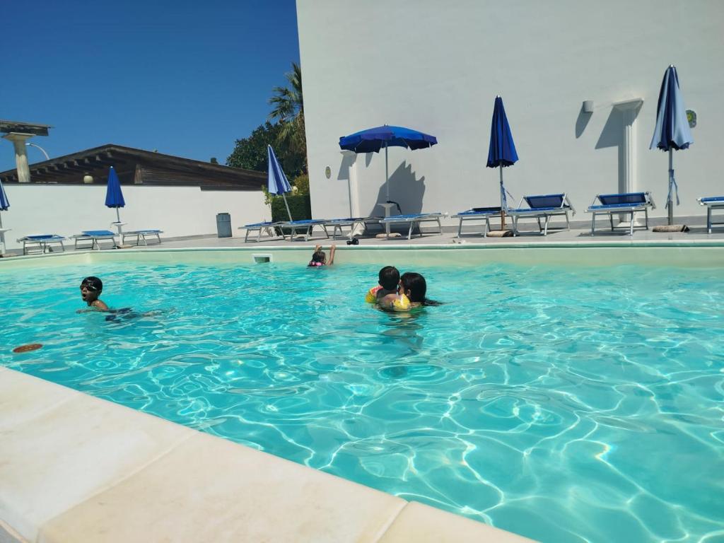 two children are swimming in a swimming pool at Casa Vacanza Stella del Mare in San Vito lo Capo
