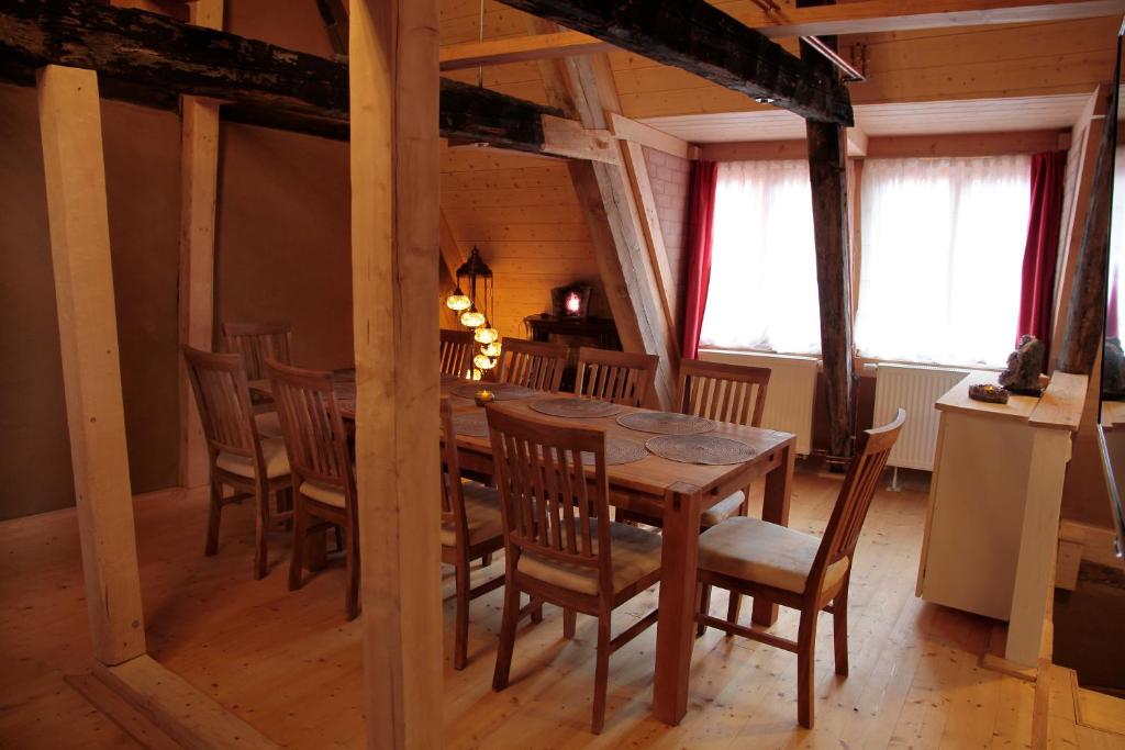 ein Esszimmer mit einem Holztisch und Stühlen in der Unterkunft Kristallhaus anno 1438 in Quedlinburg
