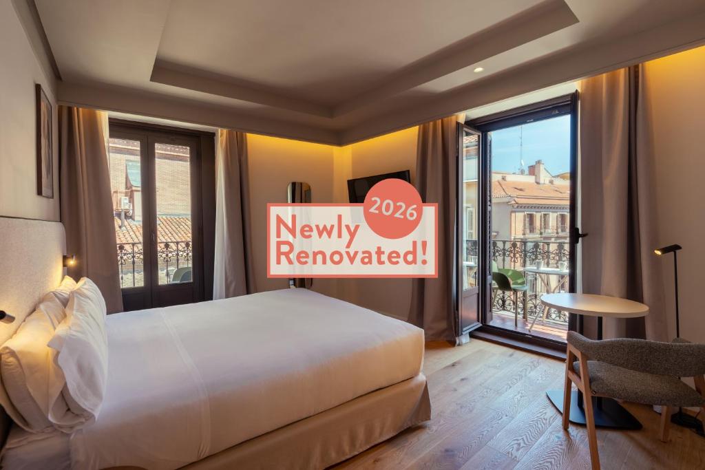a hotel room with a bed and a sign that reads newly renovated at Petit Palace Preciados in Madrid