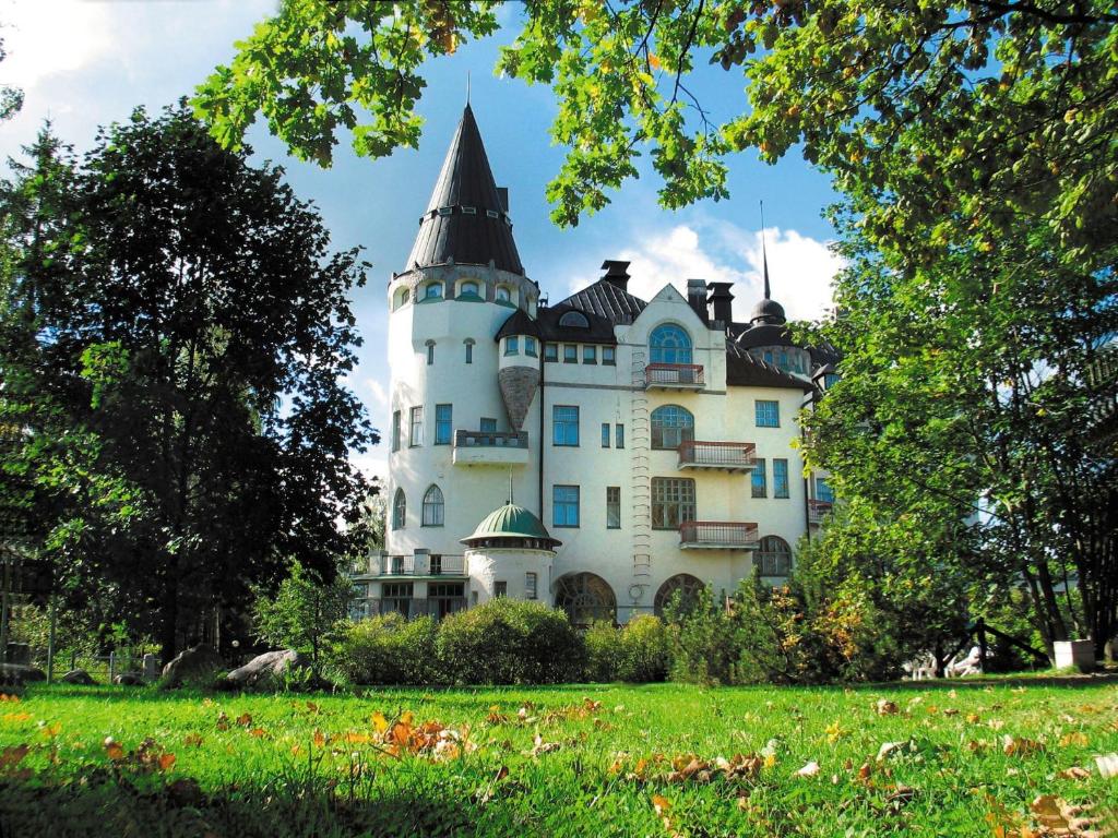 a castle in a park with a green field at Imatran Valtionhotelli in Imatra