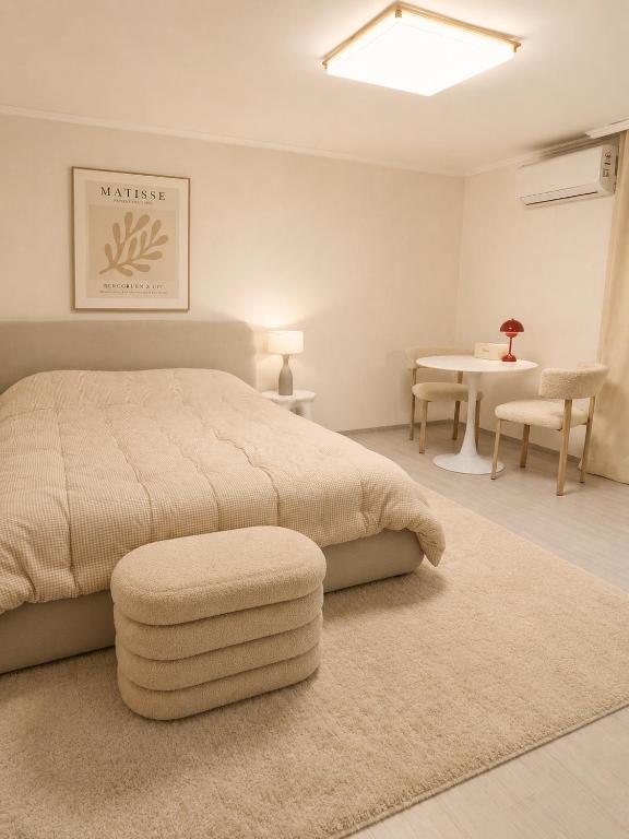 a bedroom with a large bed and a table at Coco Villa Sinsa in Seoul