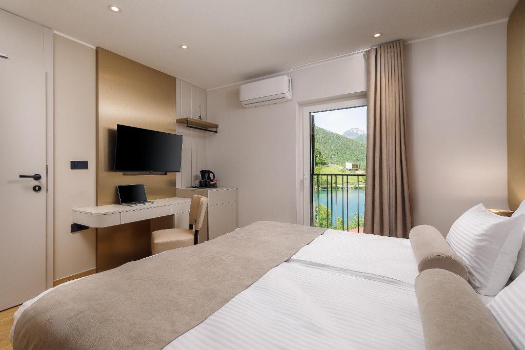 a bedroom with a bed and a desk with a computer at Guest House Jezero in Most na Soči