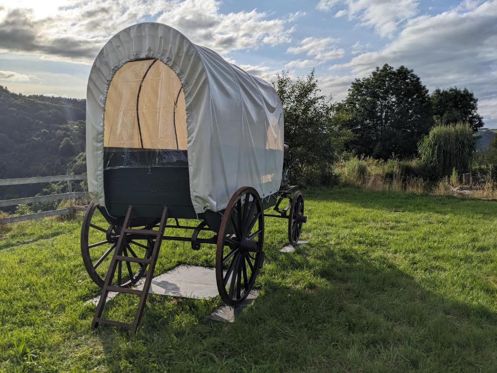 a covered wagon on display in a field at La Calèche Western in Lafarre