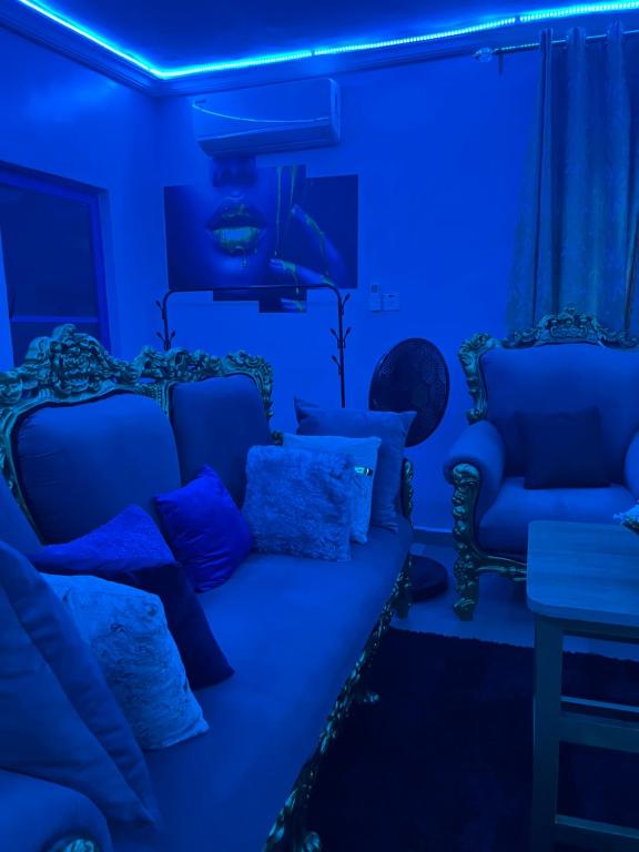 a living room with blue lighting and a couch and chairs at RYN Apartment Ayobo-Ishefun, Lagos Flat1 in Itele