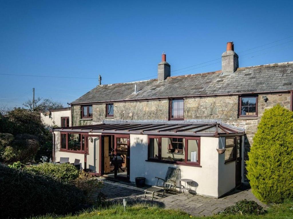 an old stone house with an awning at Trehaverock Cottage in Port Isaac