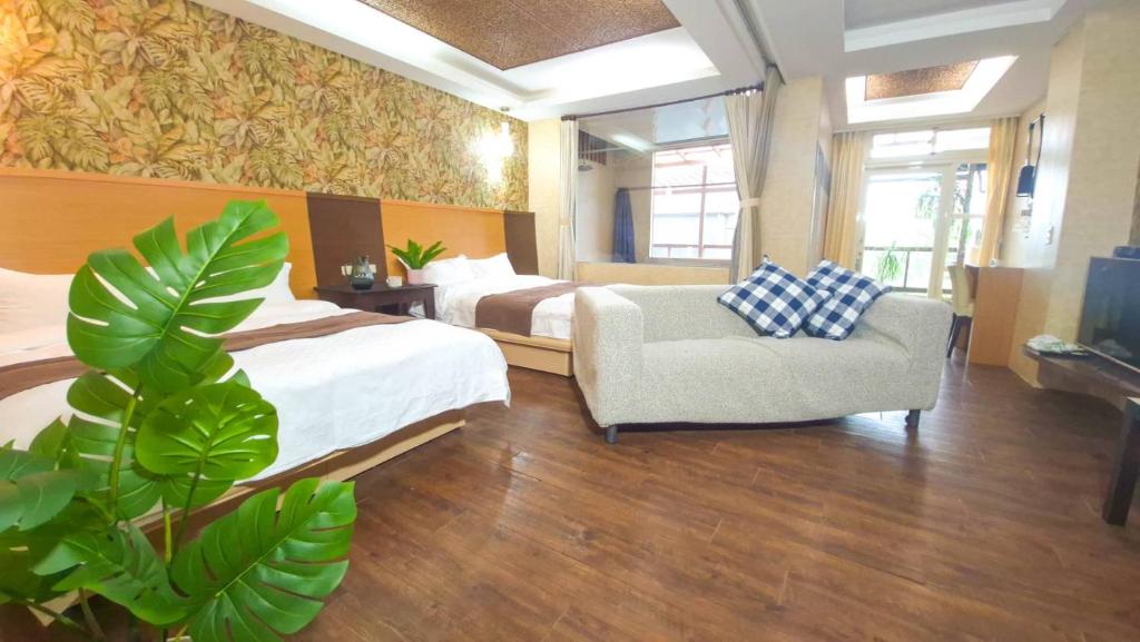 a hotel room with two beds and a chair at 青禾溫泉家民宿 in Jiaoxi
