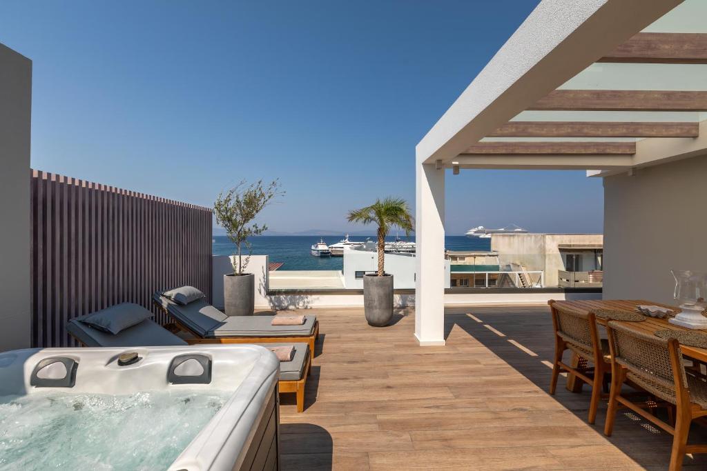 a patio with a hot tub and a table and chairs at Porto Perla in Kos