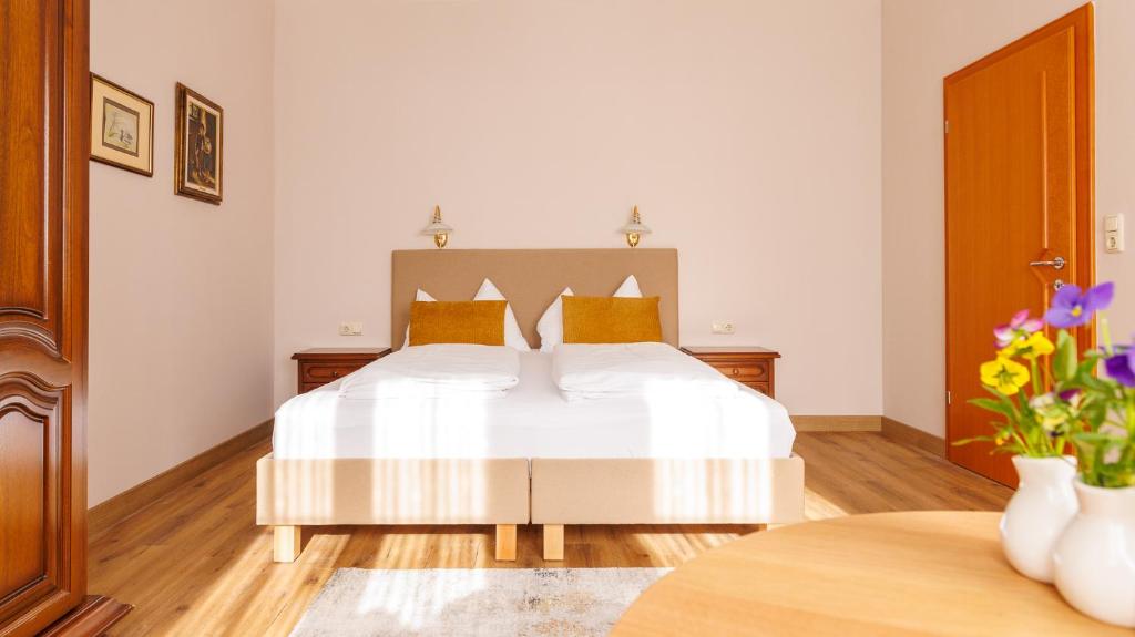 a bedroom with a bed with white sheets and yellow pillows at Apartment Gabriel in Melk