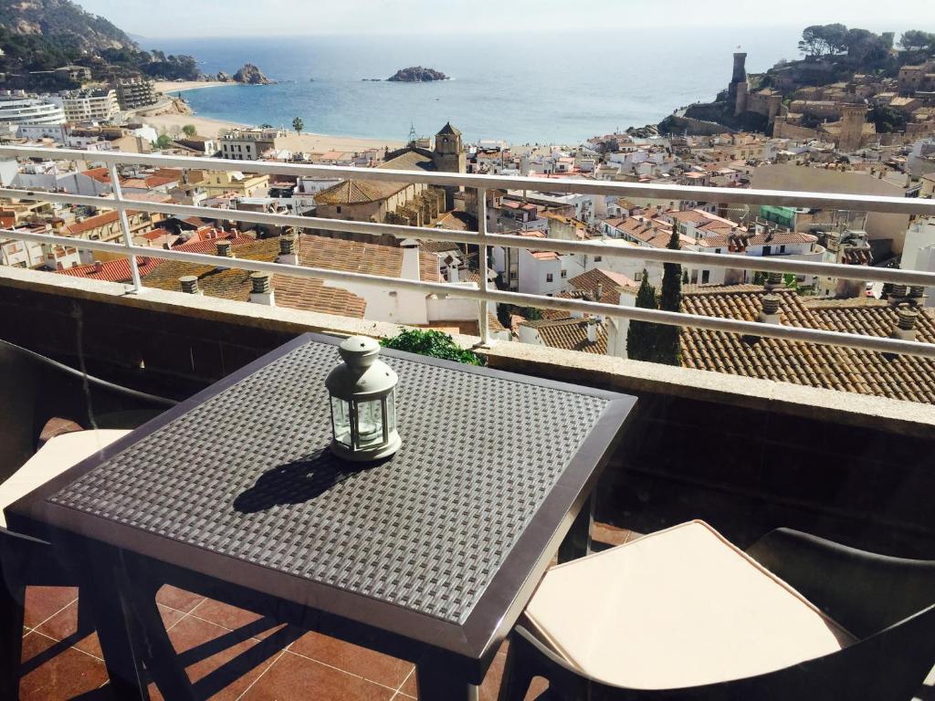 a table on a balcony with a view of the ocean at Apartamento Tossa de Mar in Tossa de Mar