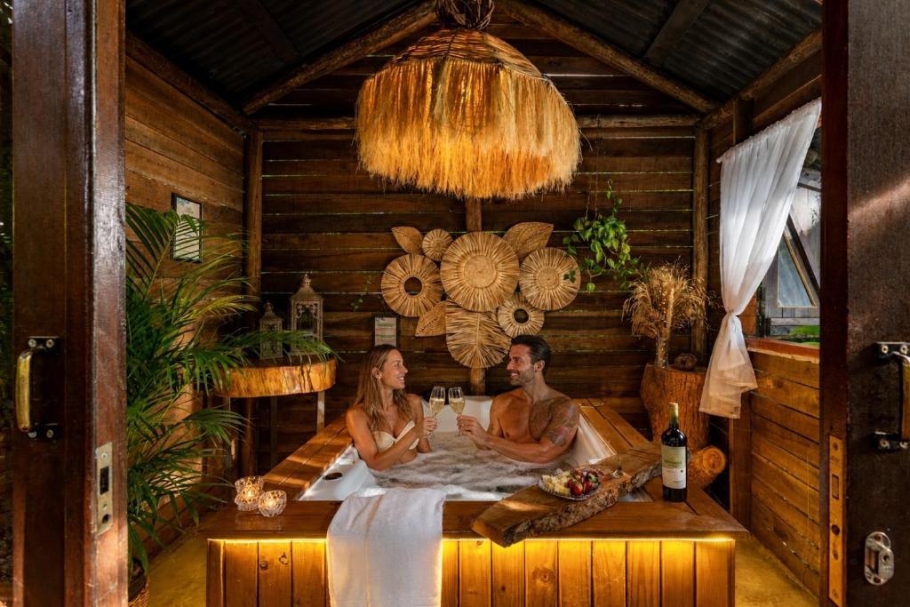 a man and a woman sitting in a bath tub at Chalés Magia do Campeche in Florianópolis