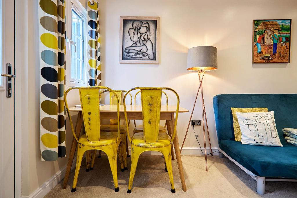 a dining room with a yellow table and chairs at The Apartment at Charles Road in Frome