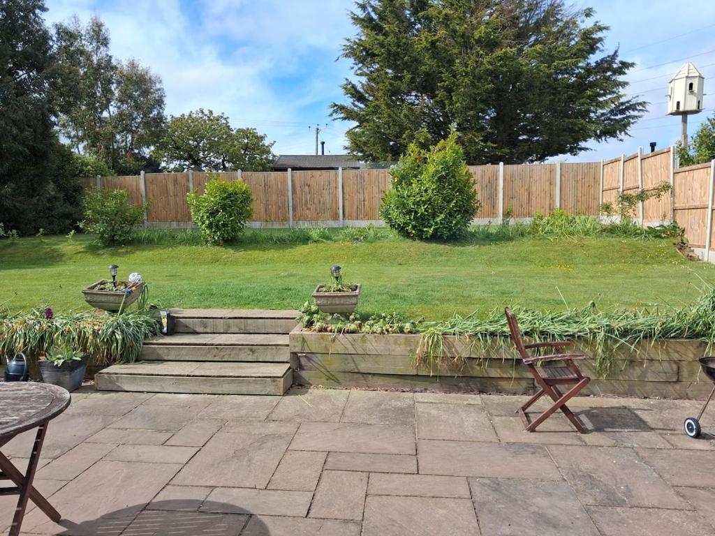 a yard with a fence and a lawn with a bench at Marley Farm Bungalow in Deal