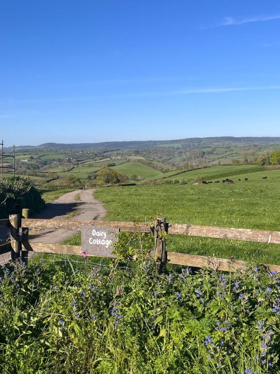 a wooden fence with a sign that reads open countryside at Dairy Cottage in Hennock