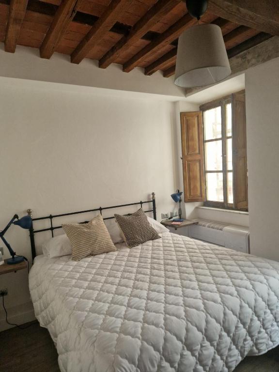a bedroom with a large bed with a white comforter at DuomoHome1 in Pietrasanta