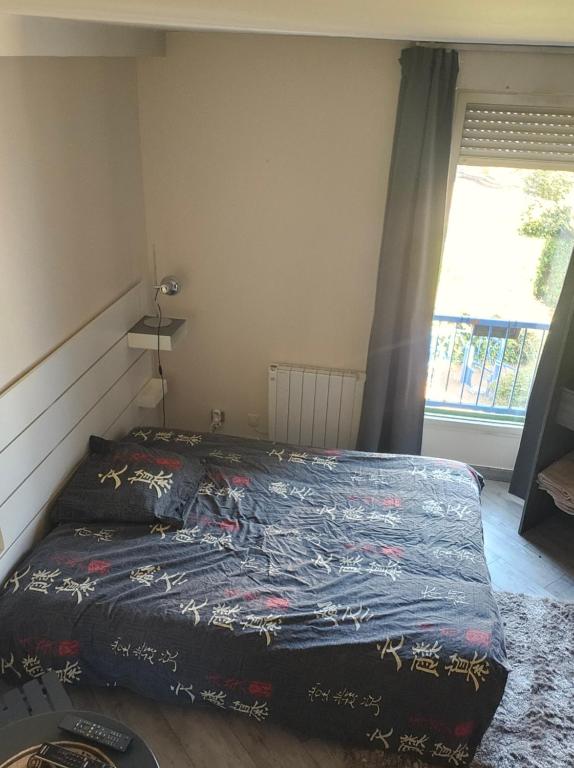 a bedroom with a bed with a quilt on it at Nuits Dijon Chambre in Dijon