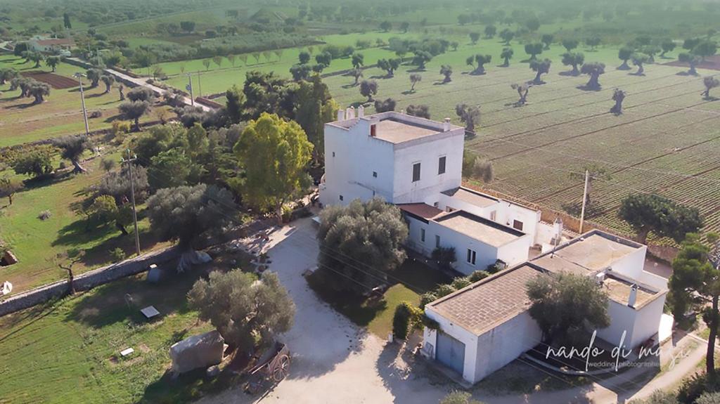 an aerial view of a large white building with trees at Masseria Giangrande - Rooms and Apartment in Polignano a Mare