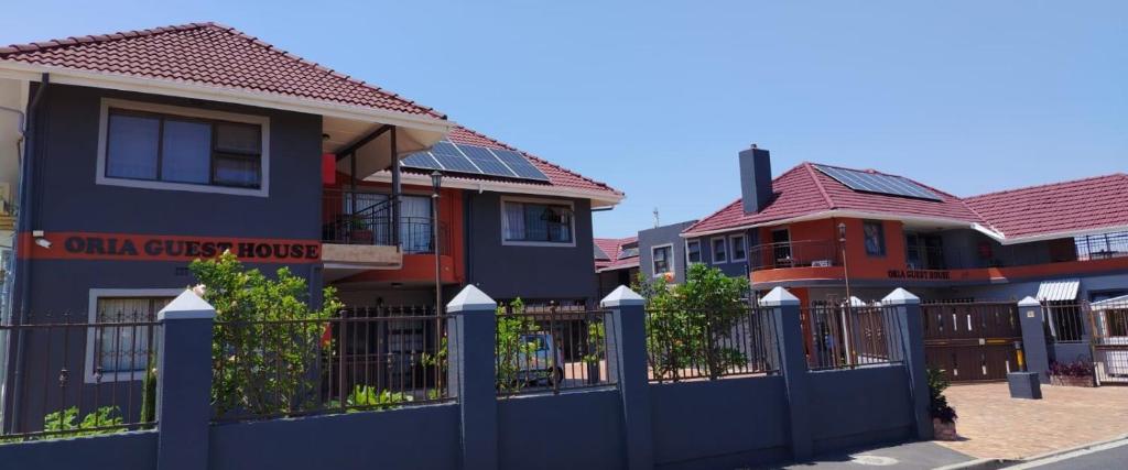 a row of houses with a blue fence at Oria Guest House in Cape Town