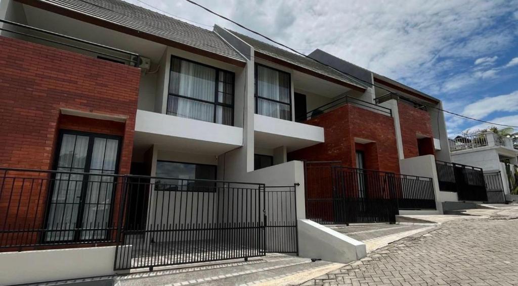 a red brick building with a black fence at Villa Grand Metro in Batu
