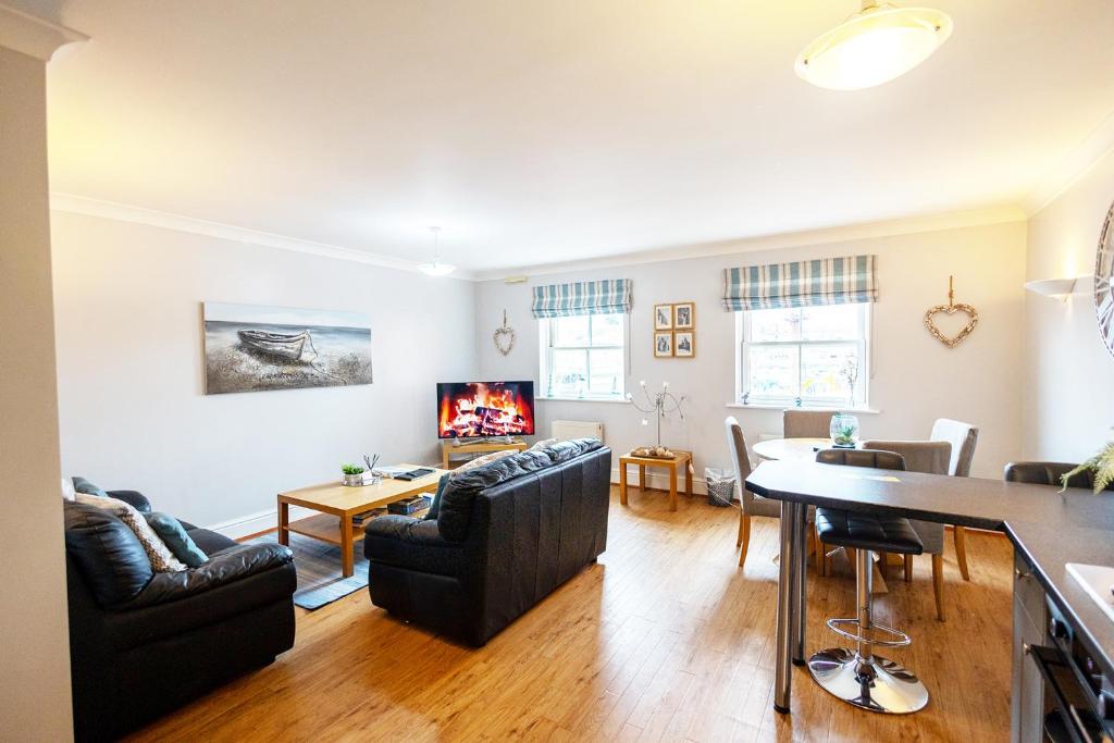 a living room with two couches and a table at Harbourside View Whitby in Whitby