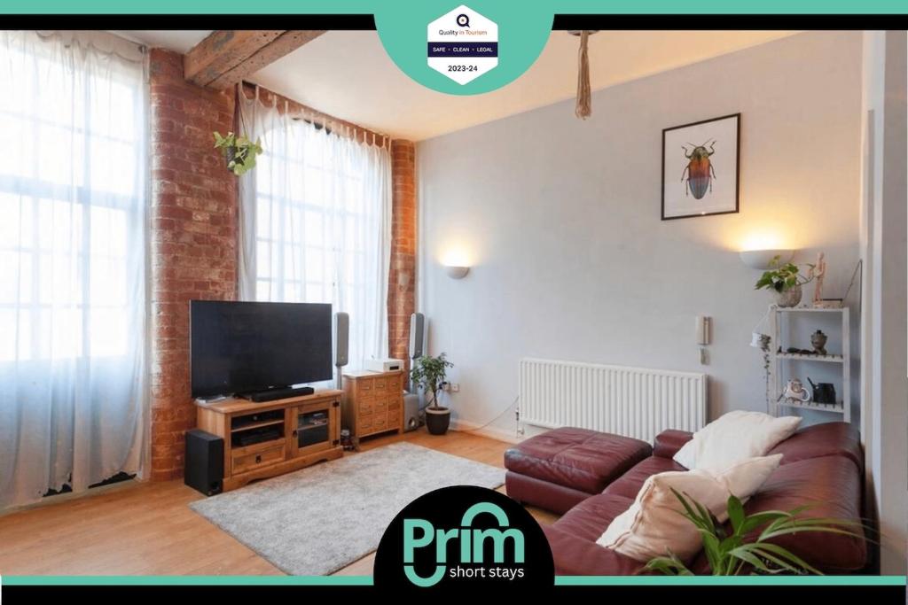a living room with a couch and a flat screen tv at Raleigh Loft in Nottingham