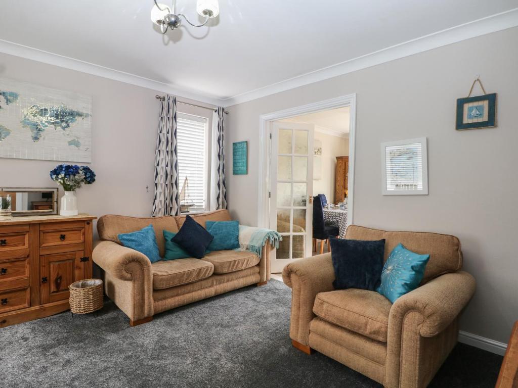 a living room with two chairs and a couch at The Willows in Dymchurch