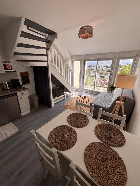 a kitchen and living room with a table and chairs at Ti Mad, Echappée belle à La Baule - mer et piscine in Guérande