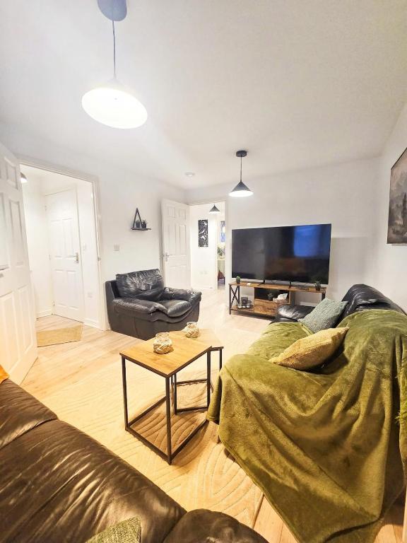 a living room with a couch and a flat screen tv at Central Hideout in Birmingham