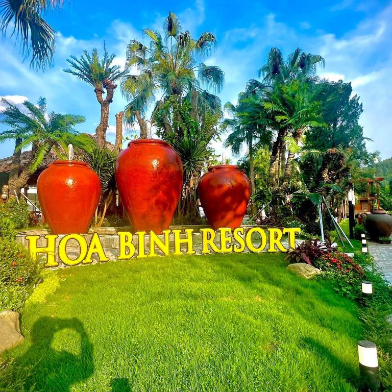 a sign for a hola balutt resort with three large vases at Hoa Binh Resort in Hòa Bình