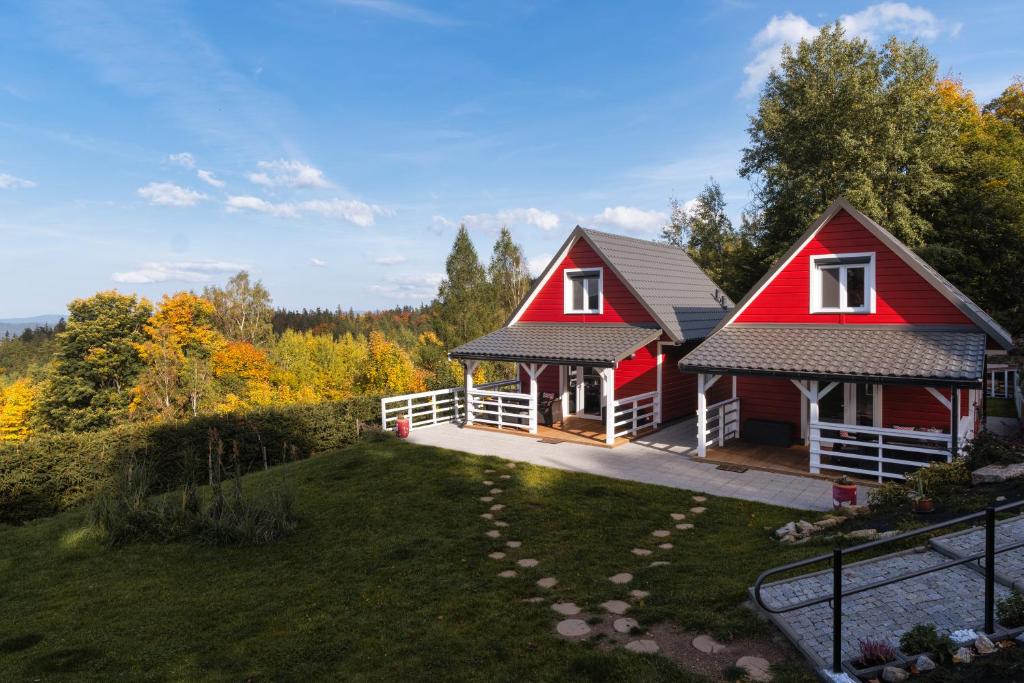 a house with a red roof and a yard at Domki w Jarzębinach - Domek z widokiem in Piechowice