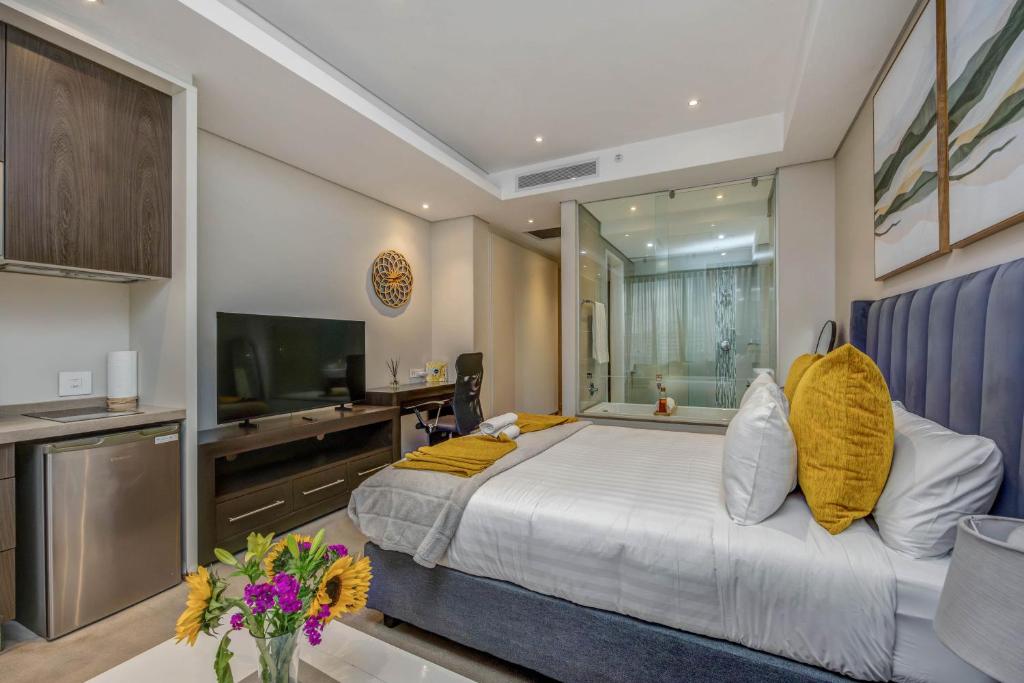 a bedroom with a large bed and a television at Sandton Skye Unit 1110 in Johannesburg