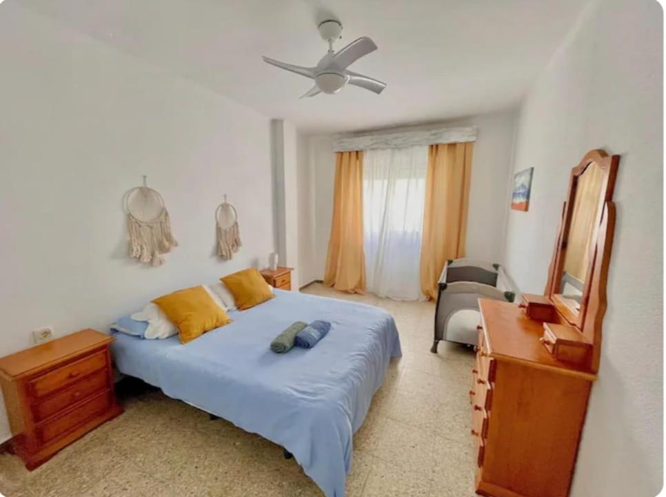 a bedroom with a bed and a dresser and a mirror at Barbate Beach Apartment in Barbate