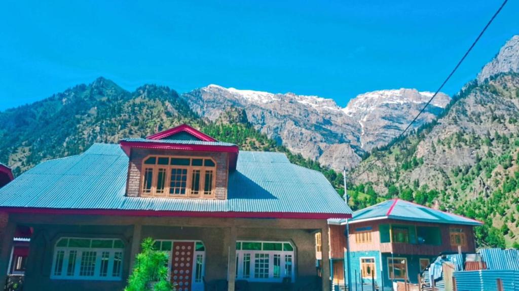 a house with mountains in the background at Forest Glen Cottage in Wāmpor