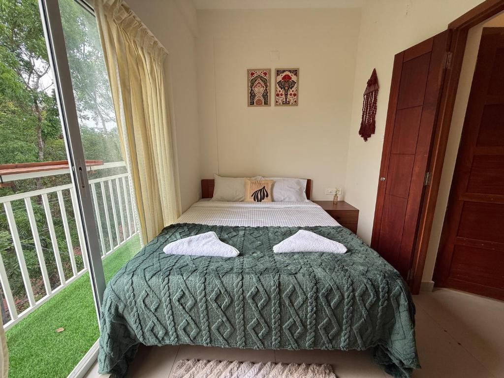 a bedroom with a bed and a balcony at Little Retreats in Nedumbassery