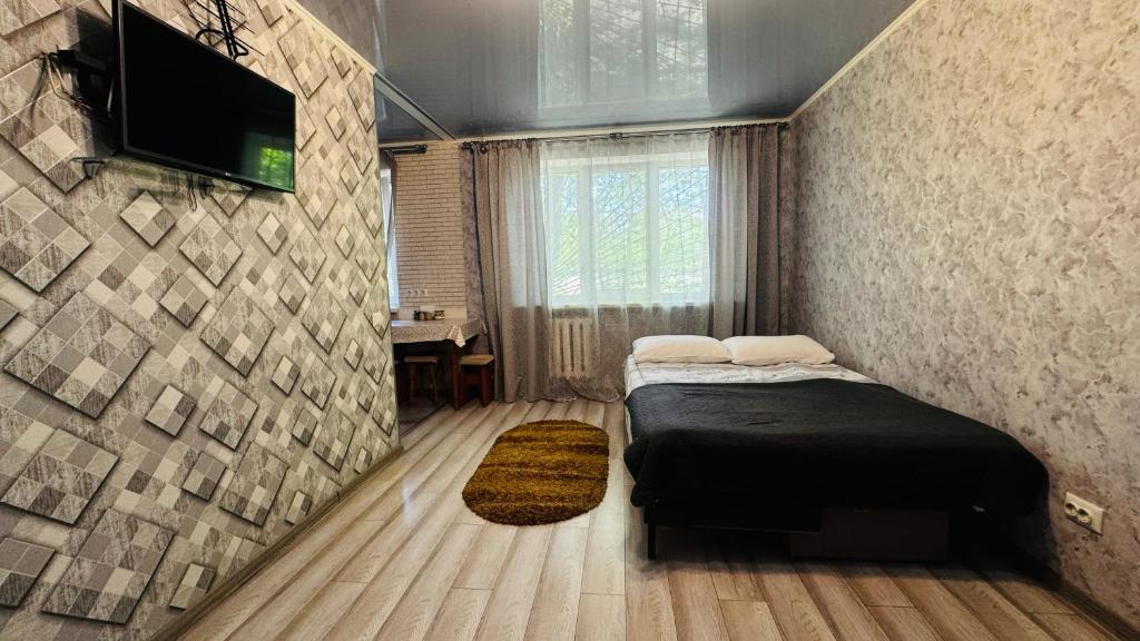 a bedroom with a bed and a television on a wall at Vinnytsia, Vyshenka in Vinnytsya