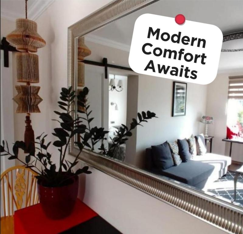 a mirror in a living room with a couch at Elen White Apartment in Rēzekne