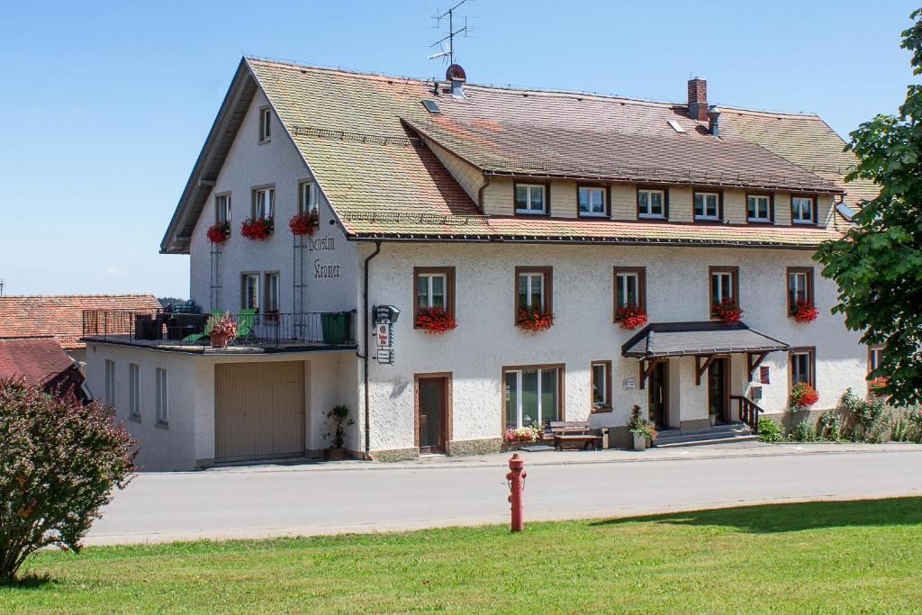 a large white building with a red fire hydrant in front of it at Pension Kramer in Grafenhausen