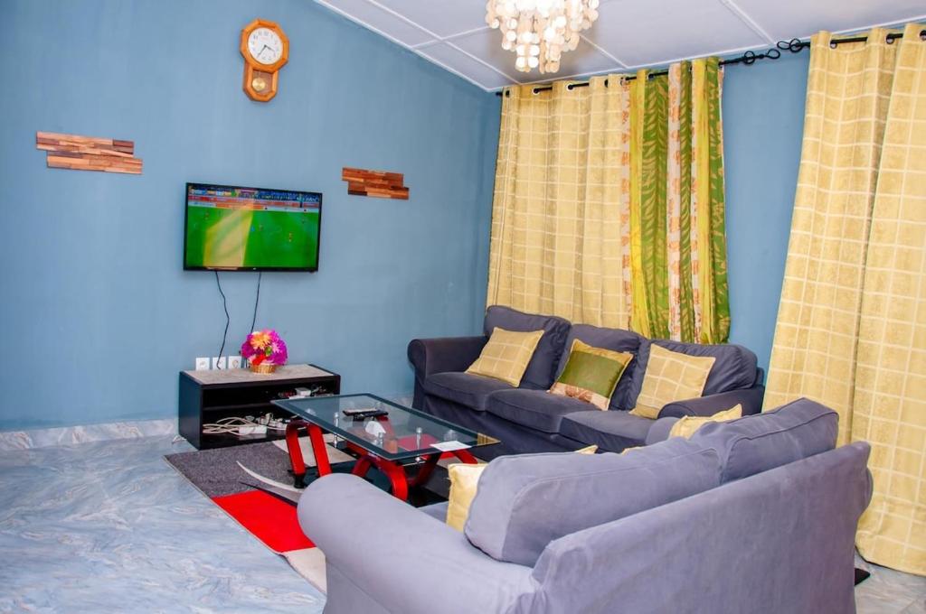 ein Wohnzimmer mit zwei Sofas und einem Fernseher in der Unterkunft Residence Mobagnes in Kinshasa