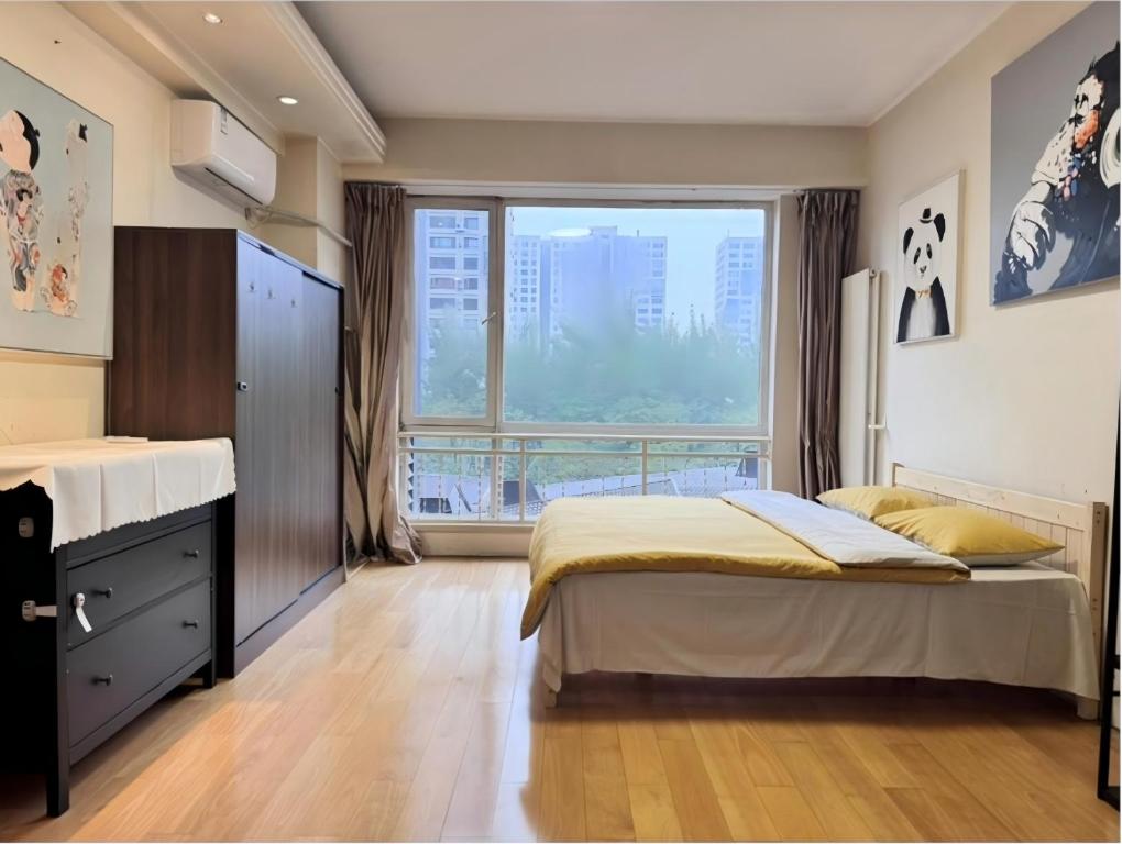 a bedroom with a bed and a large window at Beijing CBD area Cozy Family Suite in Beijing