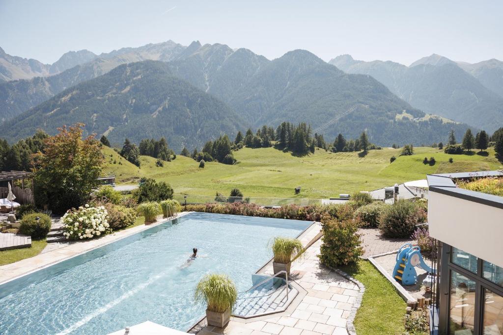eine Person in einem Schwimmbecken mit Bergen im Hintergrund in der Unterkunft Wellnessresidenz Schalber in Serfaus