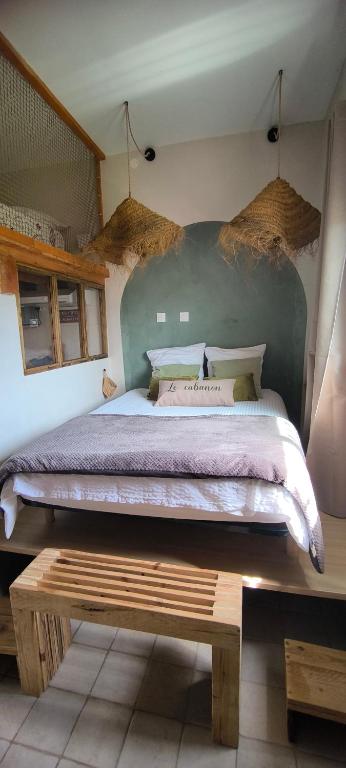 a bedroom with a large bed and a wooden bench at Cabanon cosy proche centre & plages-3 lits in Taglio-Isolaccio