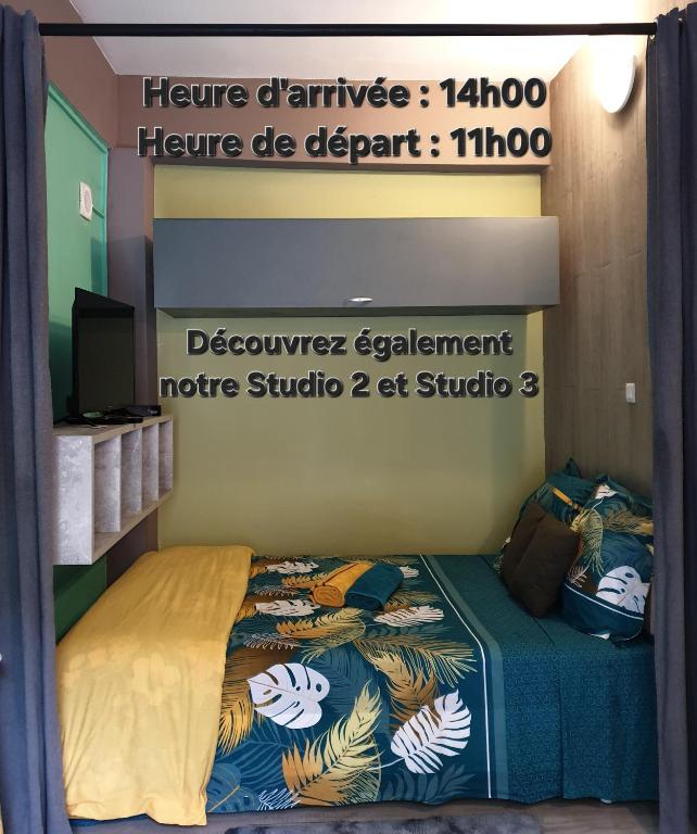 a bedroom with a bed with a sign on it at Le Bivouac du Maido studio 1 in Le Guillaume